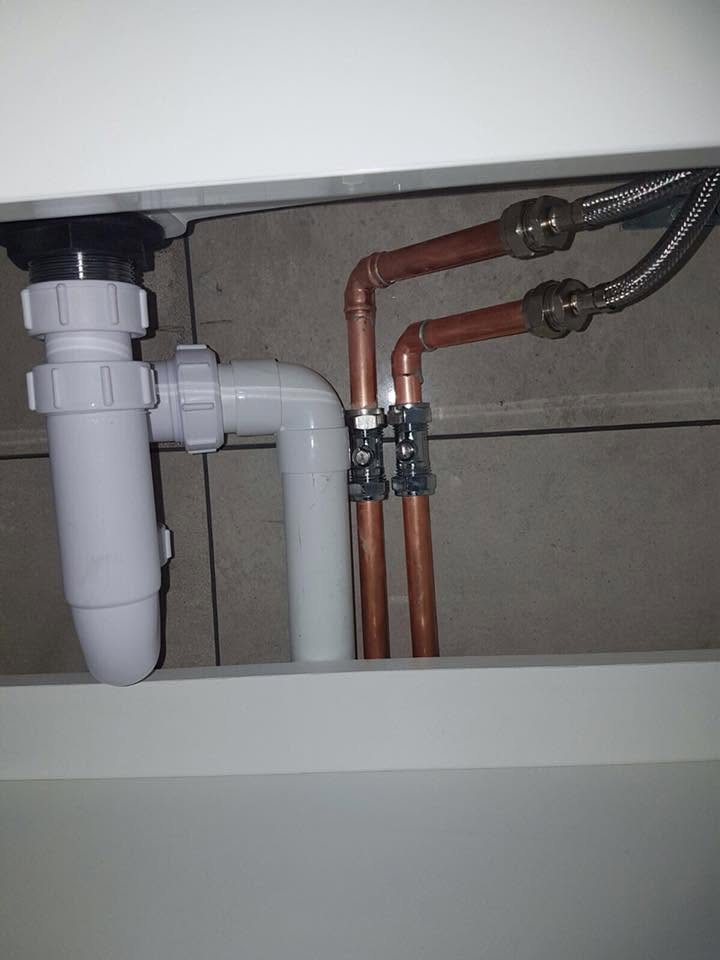 Neat copper pipework, isolation valves and waste under a basin